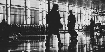 Ein schwarz-weiß Foto von Passagieren in einem Flughafenterminal.